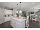 Bright open kitchen with white cabinets, stainless appliances, an island with seating and easy access to the living room at 8340 Nolandwood Ln, Villa Rica, GA 30180