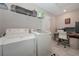 Functional laundry room with washer, dryer, utility sink, shelving and a nearby desk at 8340 Nolandwood Ln, Villa Rica, GA 30180
