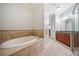 A large soaking tub is surrounded by ceramic tile in this bathroom, with cherry cabinets and granite countertops in the background at 11 Perimeter E Ctr # 1115, Atlanta, GA 30346