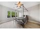 Stylish bedroom featuring a four-poster bed frame, ceiling fan, and view of trees through the window at 11 Perimeter E Ctr # 1115, Atlanta, GA 30346