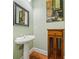 Charming powder room with a pedestal sink, hardwood floors, and decorative painting on the wall at 11 Perimeter E Ctr # 1115, Atlanta, GA 30346