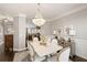 Bright dining room with a chandelier, adjacent to a kitchen with dark cabinets at 3930 Covey Flush Sw Ct # 21, Smyrna, GA 30082