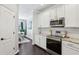 Contemporary kitchen boasting white cabinetry, stainless appliances, and a view of the dining area at 5227 Whiteoak Se Ave, Smyrna, GA 30080