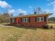 Charming one-story brick home with a bright red front door, black shutters, and a well-maintained lawn at 6120 E Fayetteville Dr, Riverdale, GA 30296