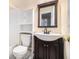 Bathroom with white vanity, decorative mirror, storage, and updated fixtures at 9610 Cedar Grove Rd, Fairburn, GA 30213