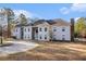 Luxury home featuring a circular driveway and three-car garage surrounded by a meticulously manicured lawn at 9610 Cedar Grove Rd, Fairburn, GA 30213