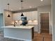 Bright kitchen with white cabinets, island, stainless appliances and open pantry, offering ample storage at 115 Laurel Farms Ln, Dallas, GA 30157