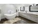 Bright bathroom featuring a freestanding tub, double vanity with granite countertop, and dark wood floors at 1666 Johnson Ne Rd, Atlanta, GA 30306