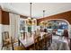 Stately dining room with large table, ornate chandelier and cozy seating area beyond an arched stone portal at 1666 Johnson Ne Rd, Atlanta, GA 30306