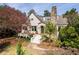 Charming home exterior with a stone chimney, lush landscaping, and a curved brick pathway leading to the front door at 1666 Johnson Ne Rd, Atlanta, GA 30306