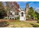 Charming home exterior with a stone chimney, lush landscaping, and a curved brick pathway leading to the front door at 1666 Johnson Ne Rd, Atlanta, GA 30306