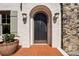 Elegant front door with arched entrance, stone accents, and a tiled porch, creating a welcoming entryway at 1666 Johnson Ne Rd, Atlanta, GA 30306