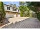 Exterior shot of a three-car garage with a basketball hoop and a large, paved driveway surrounded by trees at 1666 Johnson Ne Rd, Atlanta, GA 30306