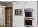 A stainless steel oven and microwave are built into the kitchen's custom white cabinets at 1666 Johnson Ne Rd, Atlanta, GA 30306