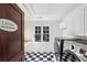 Laundry room with checkered floors, white cabinets, and a large window for natural light at 1666 Johnson Ne Rd, Atlanta, GA 30306