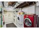Bright laundry room includes a red dryer and a white washing machine and storage shelves at 1666 Johnson Ne Rd, Atlanta, GA 30306