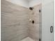 Walk-in shower featuring elegant stone-look tile and frameless glass door at 4414 Declan Dr, Kennesaw, GA 30144