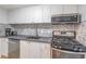 Well-equipped kitchen featuring modern appliances, white cabinets and gray backsplash at 1501 Clairmont Rd # 2016, Decatur, GA 30033