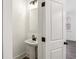 Modern half-bathroom with a pedestal sink, decorative mirror, and sleek fixtures at 1696 Gunnin Nw Trce # 244, Atlanta, GA 30318