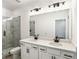 Bathroom featuring a double sink vanity, large mirror, and a glass-enclosed shower with marble tile at 1696 Gunnin Nw Trce # 244, Atlanta, GA 30318