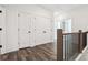 Bright hallway with dark wood grain flooring and white doors with black hardware at 1696 Gunnin Nw Trce # 244, Atlanta, GA 30318