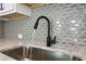 Close-up of the kitchen sink, showcasing elegant fixtures and a stylish backsplash at 1696 Gunnin Nw Trce # 244, Atlanta, GA 30318