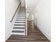 Stylish staircase with hardwood steps, white risers, and a stained wood handrail at 1696 Gunnin Nw Trce # 244, Atlanta, GA 30318