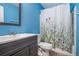 Bathroom with blue walls, and white shower curtain with floral design at 410 Bowen Ne Rd, White, GA 30184
