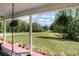 Inviting covered front porch with swing, potted plants, and a serene view of the lush yard at 410 Bowen Ne Rd, White, GA 30184