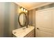 Bathroom featuring a sink, oval mirror, and decorative sconce lighting at 12710 Old Surrey Pl, Roswell, GA 30075