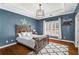 Cozy bedroom with hardwood floors, a tray ceiling, and a rustic wood bed at 12710 Old Surrey Pl, Roswell, GA 30075