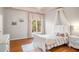 Well-lit bedroom with hardwood floors, large window, and a white bed with canopy at 12710 Old Surrey Pl, Roswell, GA 30075