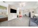 Large bonus room with built-in window seating, television, and view into a study area at 12710 Old Surrey Pl, Roswell, GA 30075