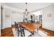 Formal dining room featuring hardwood floors, trim, and adjacent rooms at 12710 Old Surrey Pl, Roswell, GA 30075