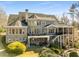 Back elevation of a luxurious brick home featuring multiple levels and a covered deck at 12710 Old Surrey Pl, Roswell, GA 30075