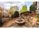 Beautiful outdoor fire pit area surrounded by natural stone seating and lush landscaping at 12710 Old Surrey Pl, Roswell, GA 30075