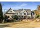 Beautiful two-story brick home with manicured lawn, stone accents, and a covered front porch at 12710 Old Surrey Pl, Roswell, GA 30075