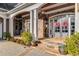 Inviting front porch featuring stone columns, elegant double doors with wreaths, and detailed stonework at 12710 Old Surrey Pl, Roswell, GA 30075