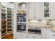 Modern kitchen featuring built-in stainless-steel appliances, a pantry, and granite countertops at 12710 Old Surrey Pl, Roswell, GA 30075