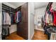 Spacious walk-in closet with custom shelving, drawers, and hardwood floors at 12710 Old Surrey Pl, Roswell, GA 30075