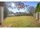 Large, grassy backyard featuring a wooden fence, sparse trees, and a storage shed on the left at 2796 Georgian W Dr, Brookhaven, GA 30341