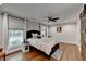 Comfortable bedroom with a ceiling fan, barn door, windows, and wood floors at 7185 Peachtree Dunwoody Rd, Atlanta, GA 30328