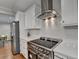 Modern kitchen with stainless steel appliances, quartz countertops, and stylish range hood at 7185 Peachtree Dunwoody Rd, Atlanta, GA 30328