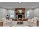 Cozy living room with a stone fireplace, plush seating, and natural light filtering through the windows at 7185 Peachtree Dunwoody Rd, Atlanta, GA 30328