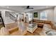 Inviting living room featuring a leather sectional, hardwood floors, and an abundance of natural light at 7185 Peachtree Dunwoody Rd, Atlanta, GA 30328