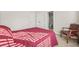 Bedroom with red quilt, adjacent bathroom and seating at 1331 Ashbury Park Dr, Hoschton, GA 30548