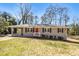 Charming brick home featuring a bright red front door and a covered carport at 1113 Grace Sw St, Mableton, GA 30126