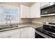 Refreshed kitchen with stainless steel appliances, white cabinets, and natural light at 1113 Grace Sw St, Mableton, GA 30126