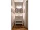 Bathroom featuring hard wood floors, white sink vanity, wood framed mirror and updated light fixture at 3699 Ashford Creek Ne Hl, Atlanta, GA 30319