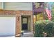 Close up of front entrance with stone facade, black door, and an American flag on upper deck at 3699 Ashford Creek Ne Hl, Atlanta, GA 30319